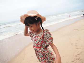 Woman wearing hat while standing on beach
