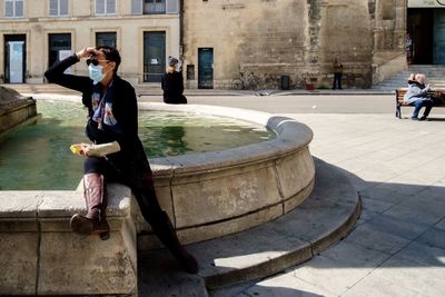 Man sitting on floor in city