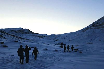 Tourists on snow covered landscape