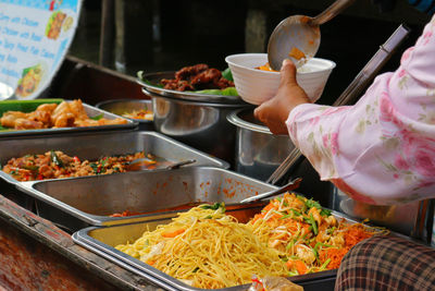 Cropped hand serving food in bowl