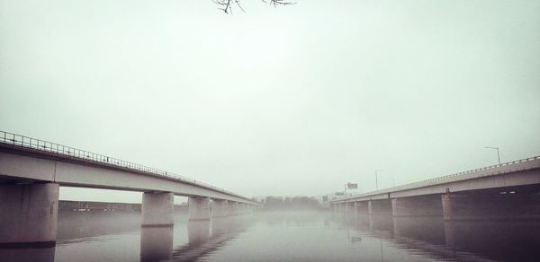 Bridge over sea against sky in city