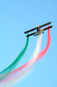 Low angle view of airplane flying against clear blue sky