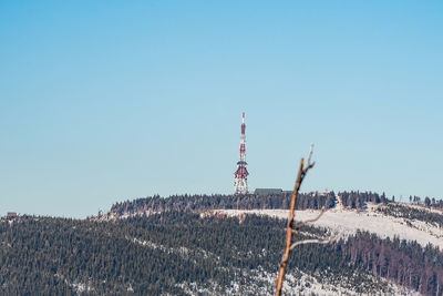 Wind turbines on land against clear blue sky