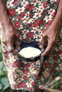 Midsection of woman holding sap in bowl