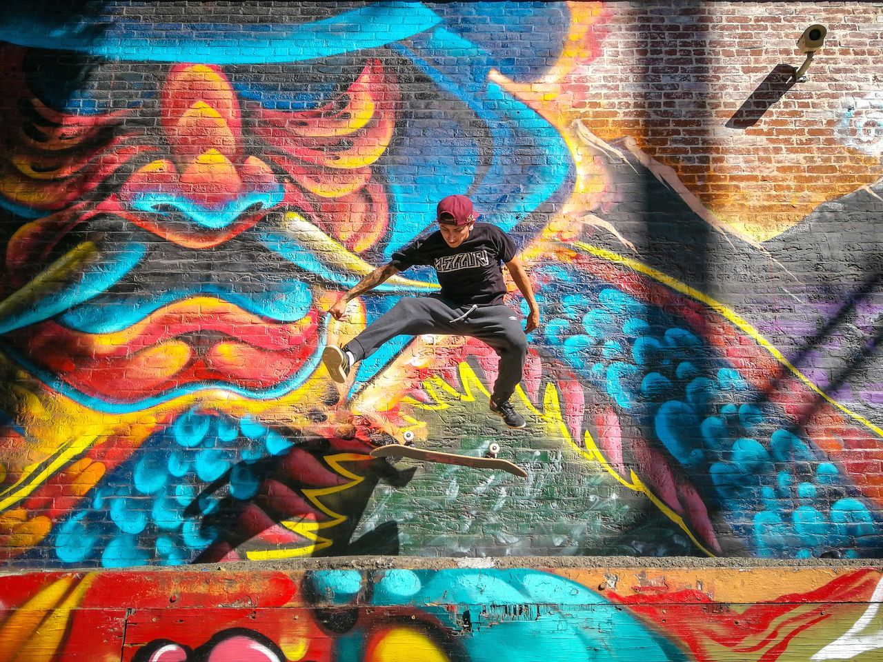 FULL FRAME SHOT OF GRAFFITI ON WALL WITH MULTI COLORED PAINTING