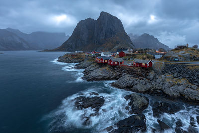 Scenic view of sea and mountains against cloudy sky