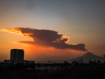 Silhouette city against sky during sunset