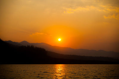 Scenic view of silhouette mountains against romantic sky at sunset