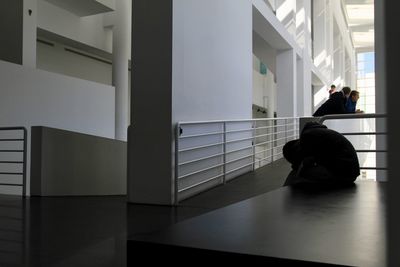 Rear view of man sitting in corridor
