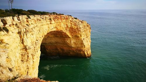 Rock formation in sea against sky