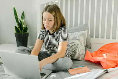 Portrait of young woman using laptop at home