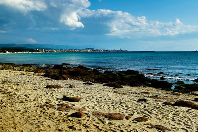 View of calm beach against blue sky