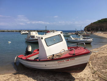 Panoramic view of boats moored on beach against sky