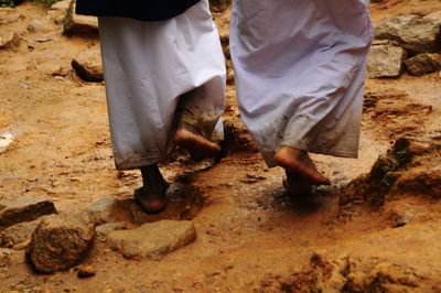 Low section of people walking on mud