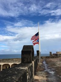 Flag on beach against sky