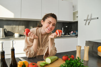 Portrait of young woman holding food at home