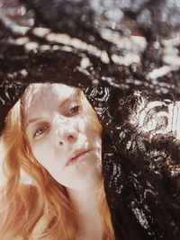 Close-up portrait of beautiful young woman with black fabric