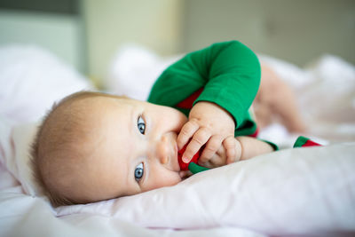 Portrait of cute baby girl lying down on bed