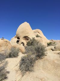 Rock formations in desert against clear blue sky