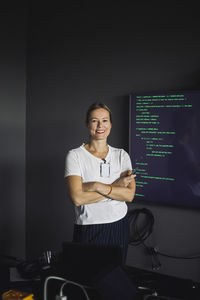 Portrait of smiling it professional working on projection screen in creative office