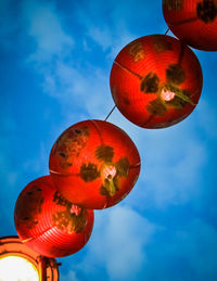 Low angle view of lanterns hanging against blue sky