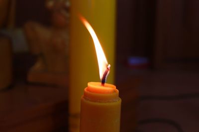 Close-up of burning candle in darkroom