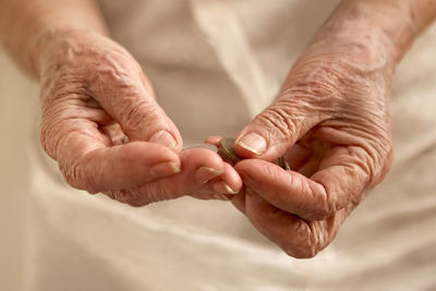 Old woman's wrinkled hands counting small coins
