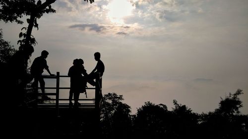 Silhouette people against sky during sunset