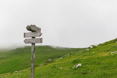 Cross on field against sky