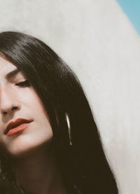 Close-up portrait of young woman against wall