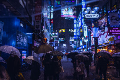 People in illuminated city at night