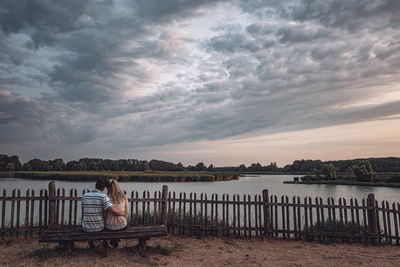 Scenic view of sea against sky during sunset with couple