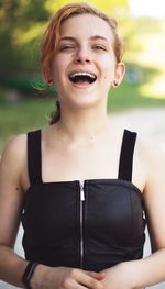 Portrait of happy young woman standing outdoors