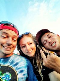Portrait of smiling young couple against sky