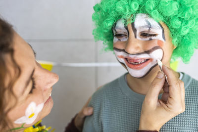 Mother painting son face