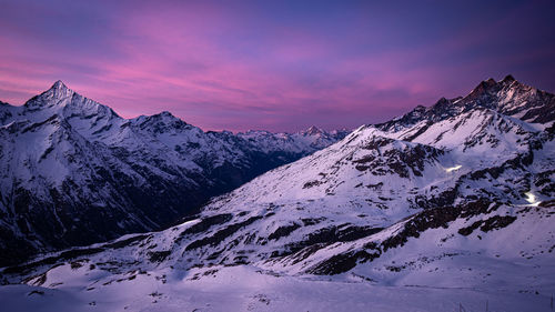 Scenic view of snowcapped mountains against sky during sunset