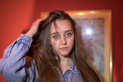 Portrait of beautiful woman against picture frame and wall