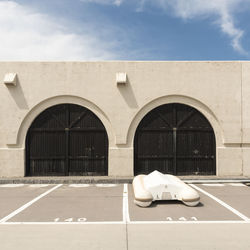 White car on road against building on sunny day