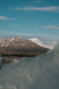 Scenic view of snowcapped mountains by sea against sky