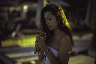 Close-up of young woman drinking drink outdoors