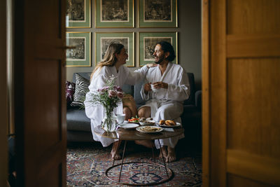 Happy couple in bathrobes in hotel room