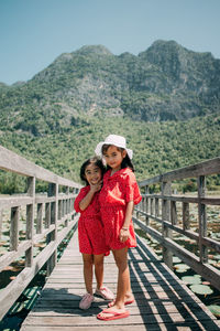 Two cute little girls standing in bridge