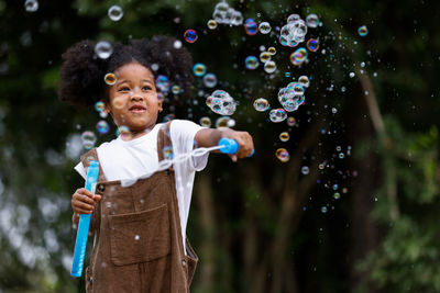 Full length of boy standing at bubbles