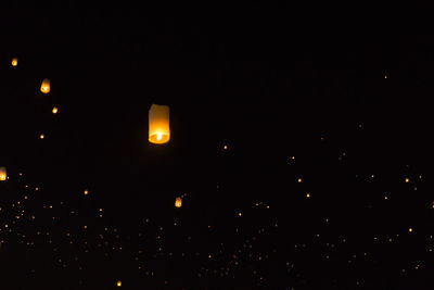 Low angle view of illuminated lantern against sky at night