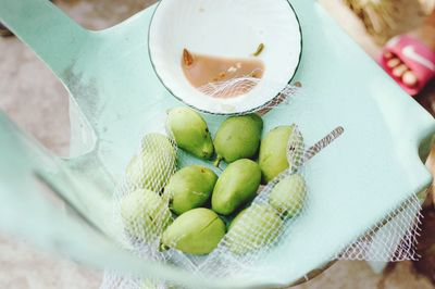 High angle view of unripe mangoes by shrimp paste on table