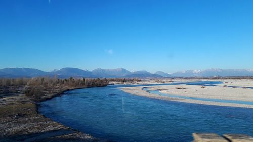 Scenic view of river against blue sky