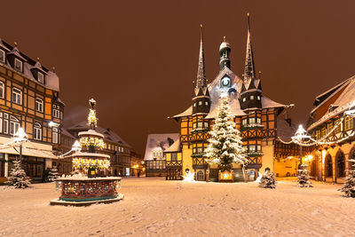 Illuminated buildings against sky at night