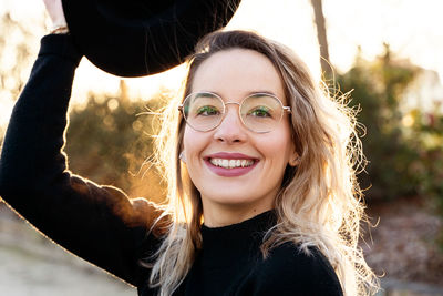 Close-up portrait of smiling young woman wearing eyeglasses