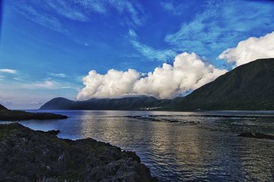 Scenic view of sea and mountains against sky