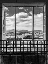 Buildings against sky seen through window